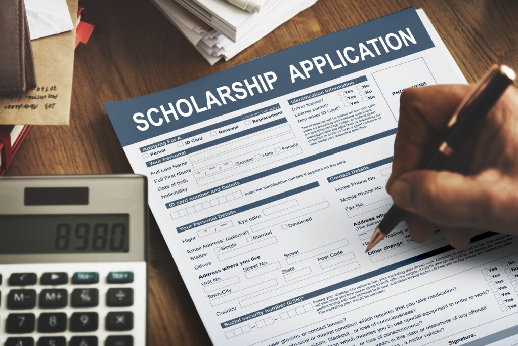 Person filling scholarship application form.