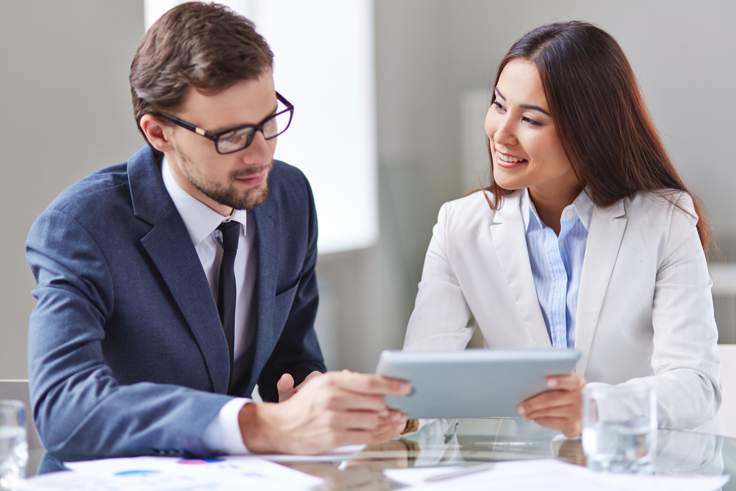 a man and woman looking at a tablet